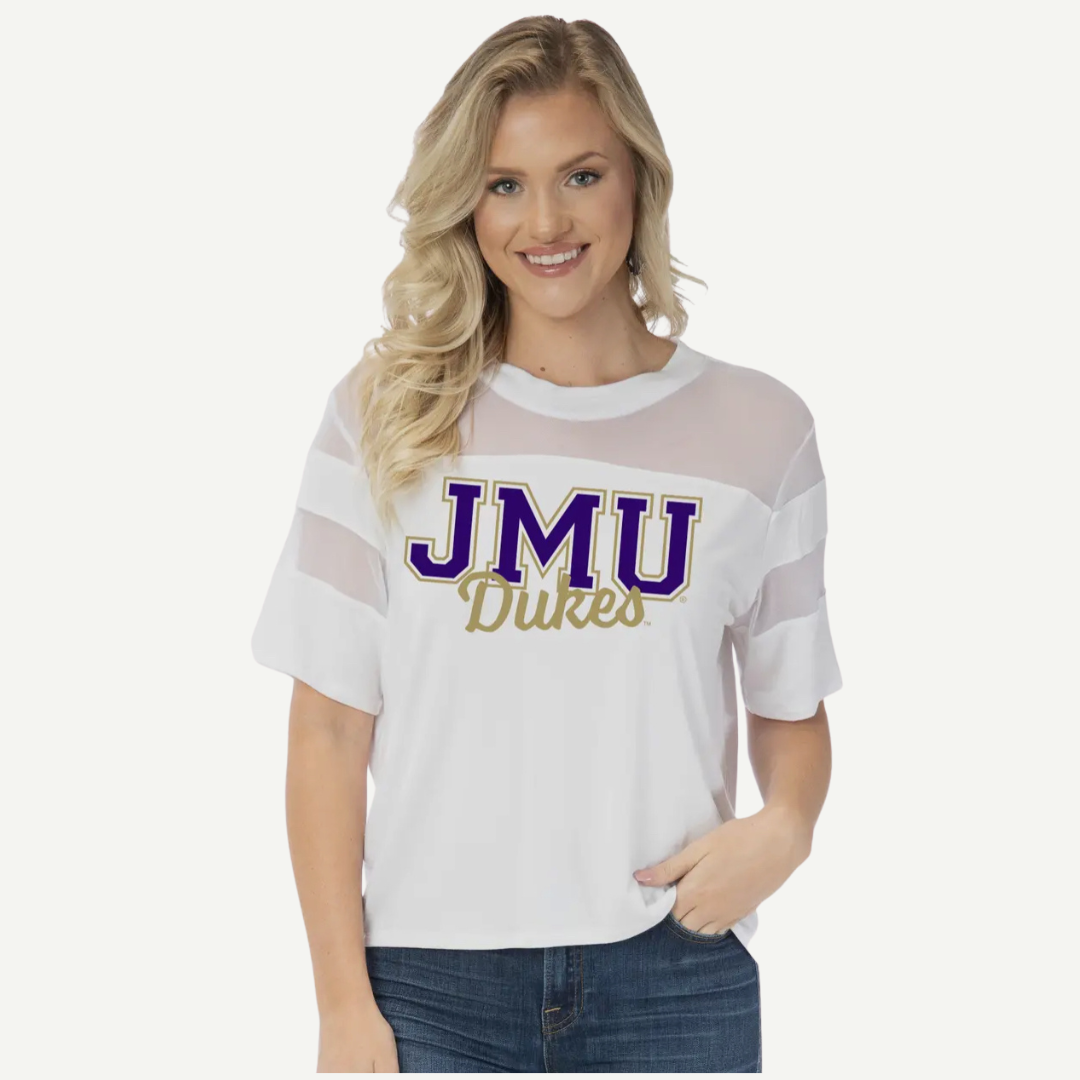 Woman wearing a white t-shirt with 'JMU Dukes' text on a plain background