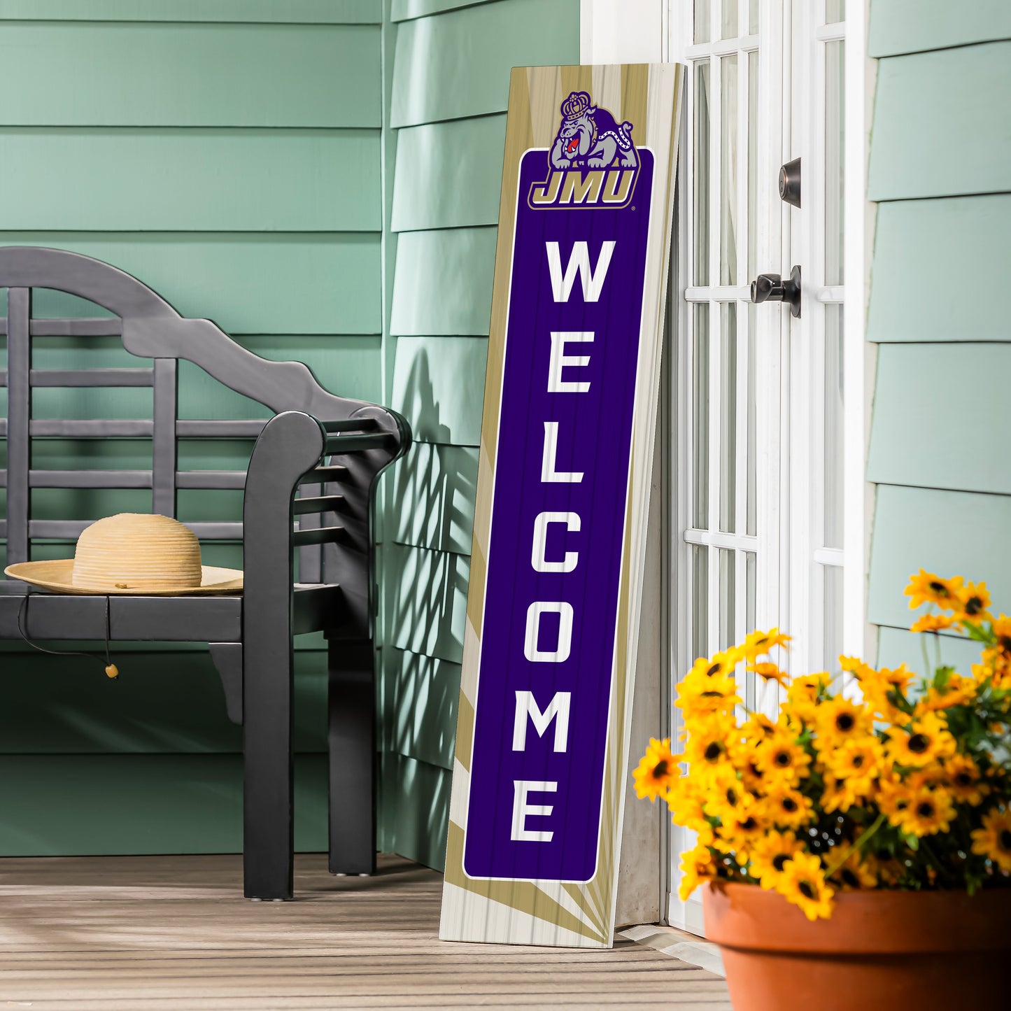 Vertical welcome sign with 'JMU' on a porch with a bench and flowers.