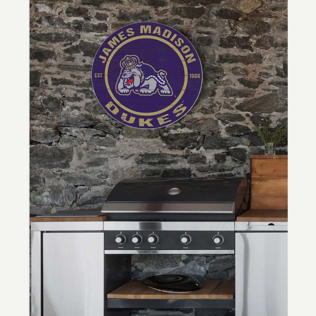 Kitchen with a stone wall featuring the James Madison Dukes logo.