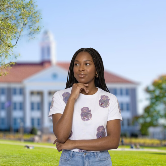 Woman standing on a grassy area with a building in the background