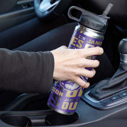 Person holding a purple and silver water bottle with text in a car.