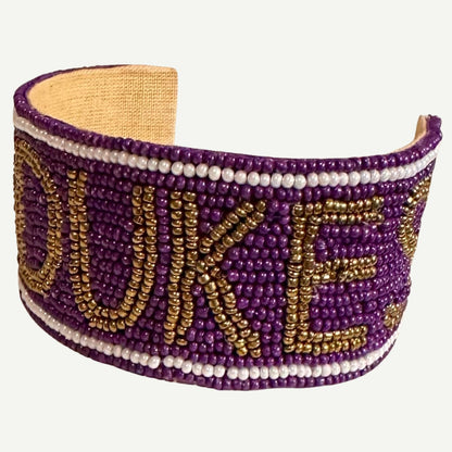 JMU Beaded Cuff featuring purple, gold, and white beadwork with the bold "GO DUKES" slogan.