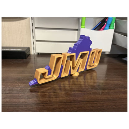 Side view of the JMU Desk Decor showing the thickness and structure of the gold letters and purple background.