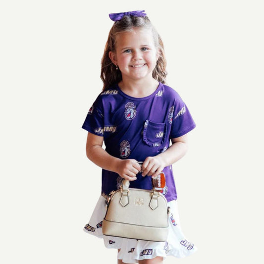 Young girl in a purple sports jersey holding a beige handbag on a white background