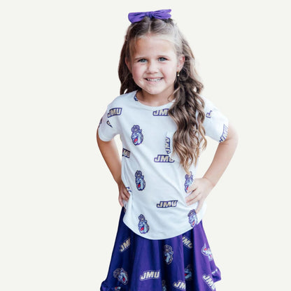 Young girl wearing a white t-shirt and purple skirt with 'JMU' print on a white background