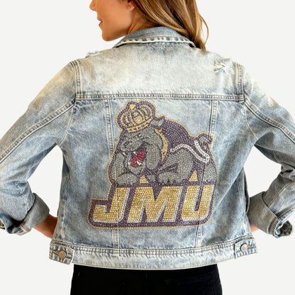 Denim jacket with a rhinestone-embellished logo and 'JMU' text on a white background