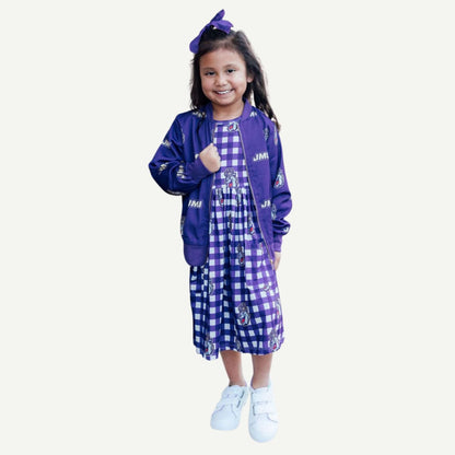 Young girl wearing a purple jacket and checkered dress on a white background