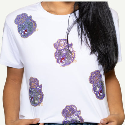 White t-shirt with purple and gold decorative elements worn by a person