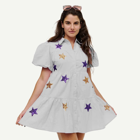Woman wearing JMU Star Smocked Dress with purple and gold sequin stars, holding out skirt.