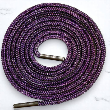 Purple shoelace with metal eyelets on a white marble background